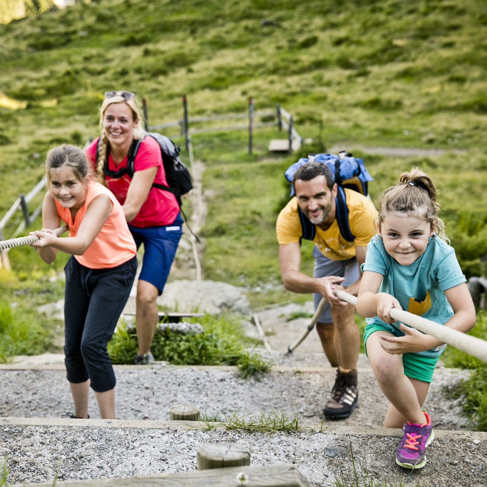 Familie erklimmen eine Spielestation am Berg in Saalbach